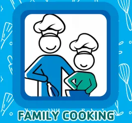 A parent and child in chef hats whisking something in a bowl.