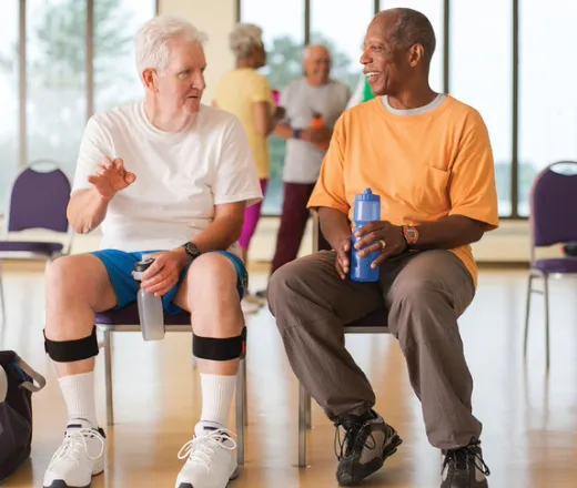 Two men talking and sitting together at a wellness program.