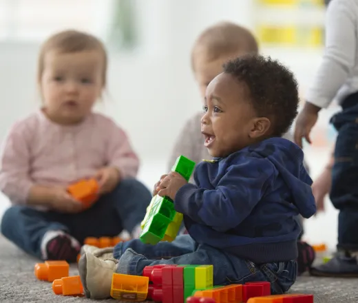 a group of toddlers playing with colorful building blocks.