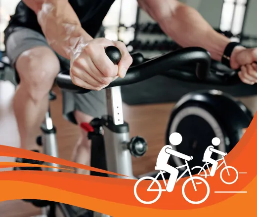 A close up shot of an older adult man riding a stationary bike.