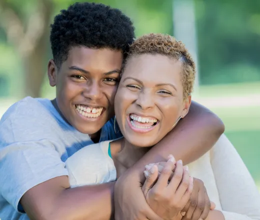 A mother being hugged by her teenage son.