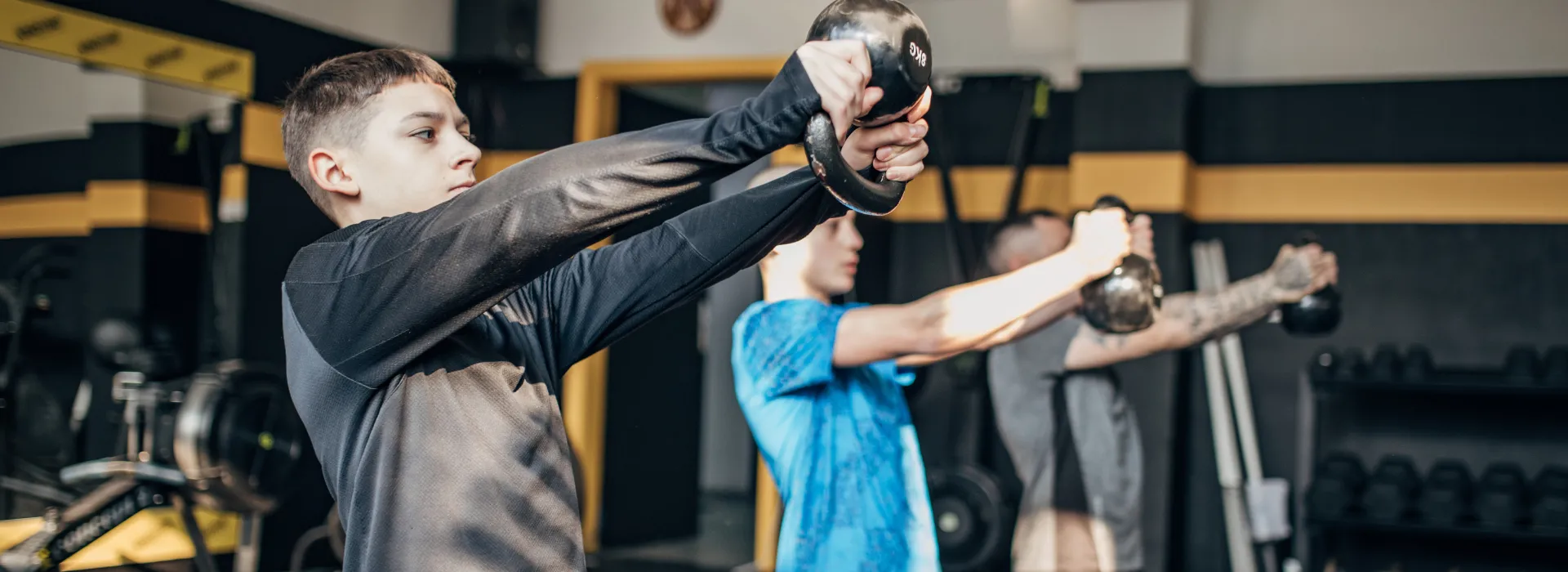 Teen boys lifting weights together