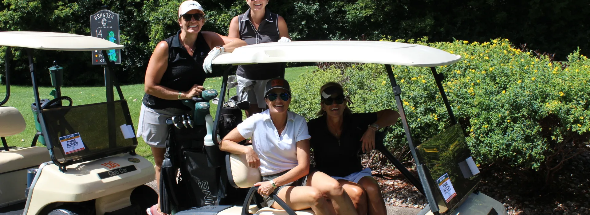 A group of women smiling in a golf cart at the annual YMCA golf outing
