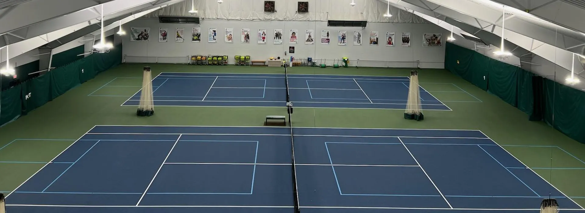 A bird's eye view shot of the inside of the tennis & pickleball center, looking down at the courts.