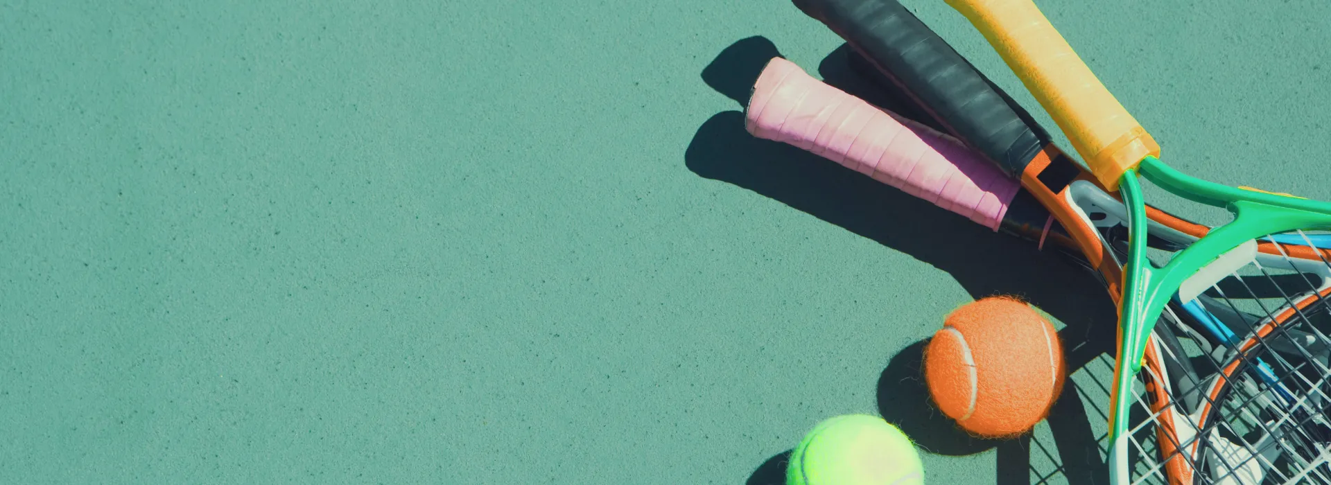 a pile of tennis & pickleball equipment on the court.